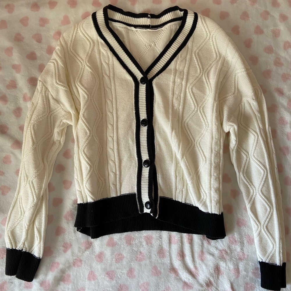 white cable knit cardigan, black lining/buttons